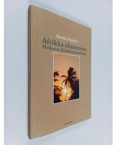 Kirjailijan Merita Mattila käytetty kirja Afrikka oburonissa : hetkessä (hiekka)puhallettu : kertomuksia Ghanasta - Oburoni Afrikassa